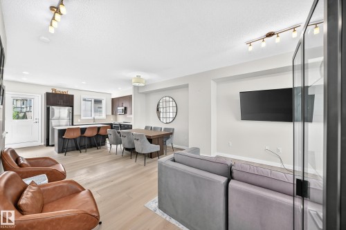 Open-concept living space featuring wood-finish flooring, recessed lighting, and a track lighting fixture - 118 655 Watt Boulevard Sw, Edmonton, AB 