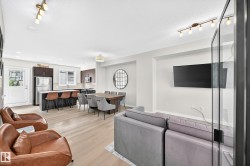 Open-concept living space featuring wood-finish flooring, recessed lighting, and a track lighting fixture - 