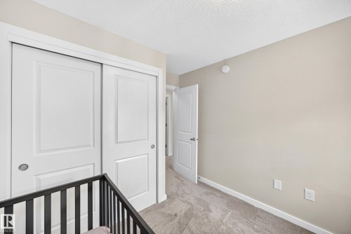 Neutral-toned wall with white trim featuring sliding panel doors - 118 655 Watt Boulevard Sw, Edmonton, AB 