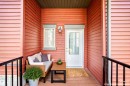 Inviting entry with rich red siding and a contrasting white door - 118 655 Watt Boulevard Sw, Edmonton, AB 