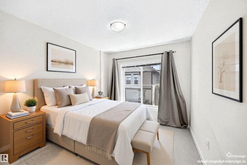 Carpeted room featuring a window with dark draperies, white walls, and a ceiling-mounted light fixture - 118 655 Watt Boulevard Sw, Edmonton, AB 