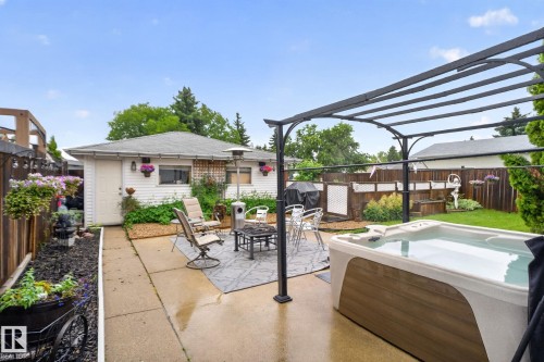 Backyard featuring a swim spa, concrete patio, and a metal pergola structure - 7539 149A Avenue, Edmonton, AB 
