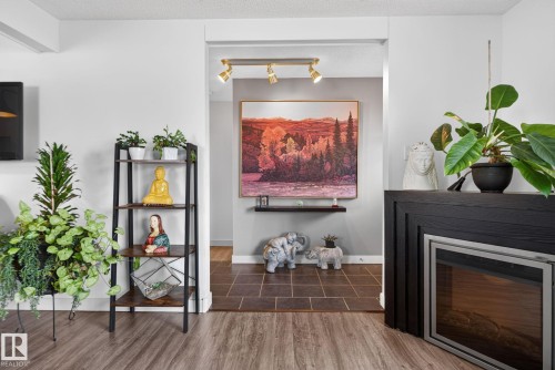 Electric fireplace with a dark wood surround and a stainless steel trim - 7539 149A Avenue, Edmonton, AB 