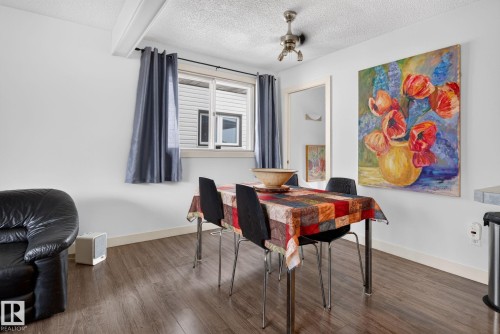 Dining area featuring wood-finish flooring and a ceiling-mounted light fixture - 7539 149A Avenue, Edmonton, AB 
