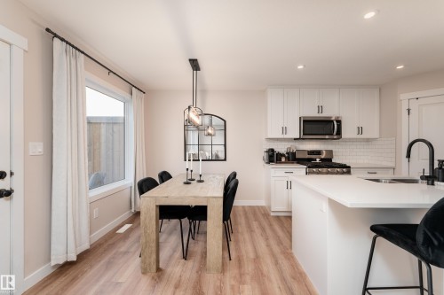 Open-concept kitchen and dining area featuring light wood-finish flooring - 584 Meadowview Drive, Fort Saskatchewan, AB 