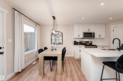 Open-concept kitchen and dining area featuring light wood-finish flooring - 