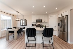 Open-concept kitchen and dining area featuring light wood-finish flooring - 