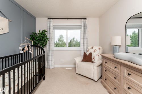 Spacious room featuring a large window, neutral wall colors, and a paneled accent wall - 584 Meadowview Drive, Fort Saskatchewan, AB 