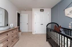 Soft neutral wall tones featuring a paneled accent wall, neutral carpeting, white shaker-style doors, and ample natural light - 