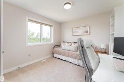 Carpeted room featuring a white-framed window, built-in shelving, and neutral wall tones - 