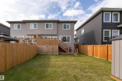 Expansive fenced backyard featuring a wood deck with stairs, a gazebo, and a storage shed - 