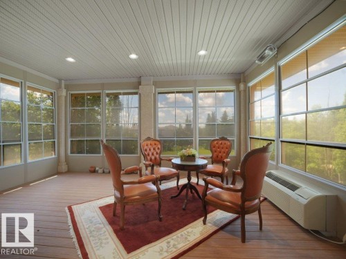 Sunroom featuring extensive window-paned walls, wood-finish flooring, and a beadboard ceiling with recessed lighting - 2423 Tegler Green, Edmonton, AB 