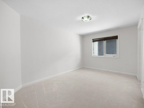 Neutral-toned carpet flooring and white baseboards - 2423 Tegler Green, Edmonton, AB 