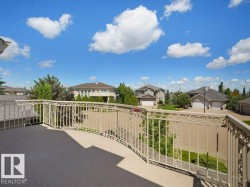 Expansive outdoor balcony featuring a decorative metal railing and a durable surface - 