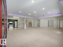 Spacious room featuring neutral carpeting, recessed lighting, and a tray ceiling with accent lighting - 