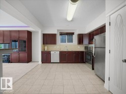 Kitchen featuring wood-finish cabinetry, stainless steel appliances, and tile flooring - 