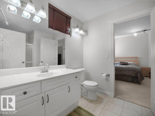 Bathroom featuring a white vanity with integrated sink, chrome faucet, and overhead lighting - 2423 Tegler Green, Edmonton, AB 