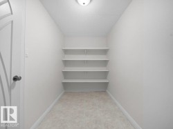 Recessed storage area featuring four built-in shelves, light neutral wall paint, and ceramic tile flooring - 