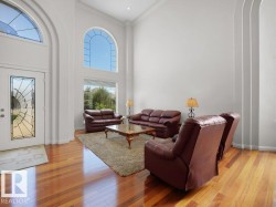 Two-story living area featuring a vaulted ceiling and wood-finish flooring - 