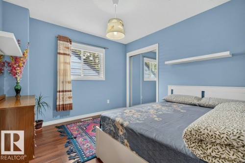 Room featuring blue walls and wood-finish flooring - 11330 101 Street, Edmonton, AB 