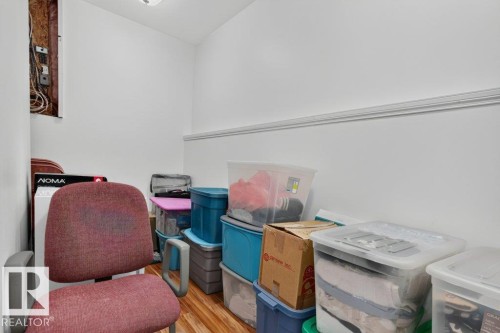Compact utility space featuring wood-finish flooring, white walls, and crown molding - 11330 101 Street, Edmonton, AB 