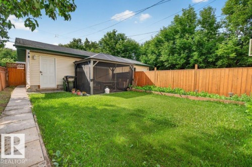 Expansive green lawn with a screened gazebo, concrete paver pathway, and a wood privacy fence - 11330 101 Street, Edmonton, AB 