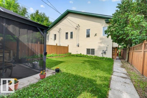 Expansive green space featuring a screened gazebo with concrete patio flooring, a concrete walkway, and a full wood fence - 11330 101 Street, Edmonton, AB 