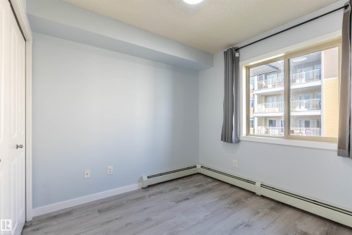 Room featuring wood-finish flooring, light blue wall paint, and white trim - 403 25 Element Dr, St. Albert, AB - Indoor Photo Showing Other Room