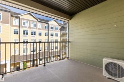 Private balcony with a concrete floor, black metal railing, and green horizontal siding - 
