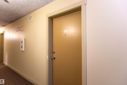 Corridor featuring textured ceiling, light-toned walls, and patterned carpet flooring - 403 25 Element Dr, St. Albert, AB - Indoor Photo Showing Other Room