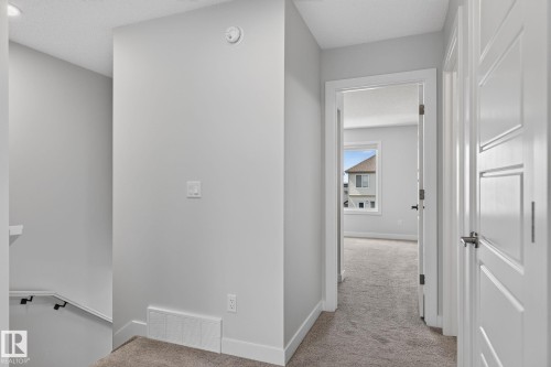 Upper-level hallway featuring light gray wall paint, white trim, and a carpeted floor - 33 11910 35 Avenue, Edmonton, AB 