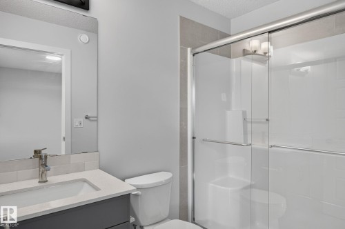 Shower enclosure with clear glass sliding doors and chrome hardware - 33 11910 35 Avenue, Edmonton, AB 