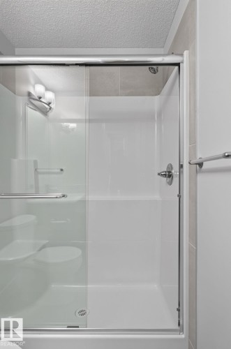 Bathroom vanity featuring a light countertop, integrated sink, and gray cabinetry with black hardware - 33 11910 35 Avenue, Edmonton, AB 