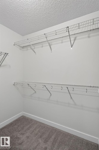 Dedicated laundry closet featuring a stacked washer and dryer unit - 33 11910 35 Avenue, Edmonton, AB 