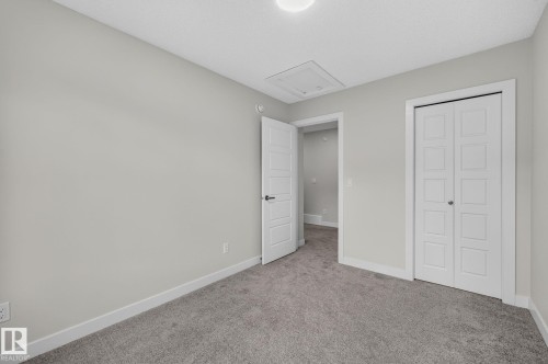 Attached single-car garage featuring a concrete floor, an overhead door with opener, exposed drywall, and a clearly visible electrical panel - 33 11910 35 Avenue, Edmonton, AB 