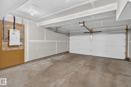 Contemporary multi-level townhome featuring horizontal siding, multiple windows with dark frames, and an integrated garage - 33 11910 35 Avenue, Edmonton, AB 