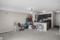 Kitchen area featuring dark wood-finish cabinetry, black appliances, and a black countertop - 