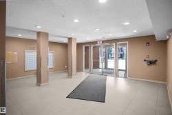 Building entry with light-toned tiled flooring, recessed ceiling lighting, and multiple mailboxes - 
