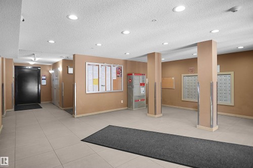 Lobby area featuring light-toned tile flooring, recessed lighting, and wall-mounted mailboxes - 215 1070 Mcconachie Blvd, Edmonton, AB 