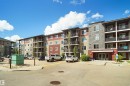 Multi-story building featuring a stone facade entrance and a mix of siding finishes - 215 1070 Mcconachie Blvd, Edmonton, AB 