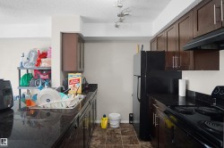 Kitchen featuring dark wood-finish cabinetry, black countertops, and a full suite of black appliances - 