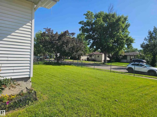 Expansive green lawn with a chain-link fence bordering the street - 4304 121 Avenue Nw, Edmonton, AB - Outdoor