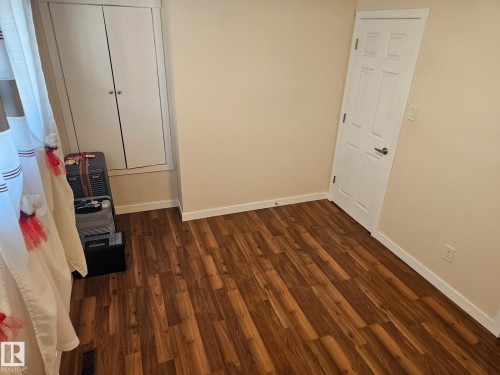 Wood-finish flooring with light beige walls and white baseboards - 4304 121 Avenue Nw, Edmonton, AB - Indoor Photo Showing Other Room