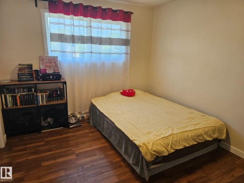 Room featuring wood-finish flooring, neutral wall paint, and a window with a curtain rod - 4304 121 Avenue Nw, Edmonton, AB - Indoor Photo Showing Bedroom