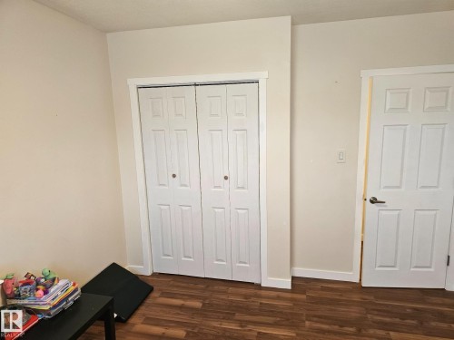 White interior doors, bi-fold closet doors, and wood-finish flooring - 4304 121 Avenue Nw, Edmonton, AB - Indoor
