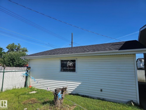 Detached garage structure featuring white horizontal siding, a dark shingle roof, and white gutters - 4304 121 Avenue Nw, Edmonton, AB - Outdoor With Exterior