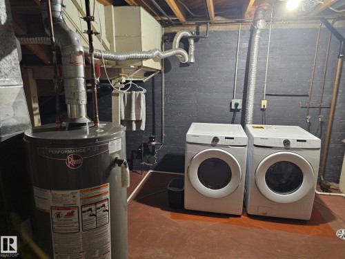 Laundry area featuring a water heater, exposed ceiling joists, and concrete flooring - 4304 121 Avenue Nw, Edmonton, AB - Indoor Photo Showing Laundry Room