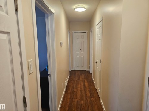 Corridor featuring wood-finish flooring, light neutral wall paint, and white trim - 4304 121 Avenue Nw, Edmonton, AB - Indoor Photo Showing Other Room