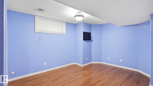 Room with wood-finish flooring, a white ceiling, and a flush-mount light fixture - 3591 Mclean Crescent, Edmonton, AB 