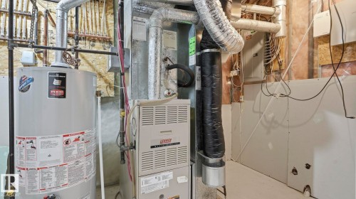 Utility area featuring a water heater, furnace, and exposed piping - 3591 Mclean Crescent, Edmonton, AB 